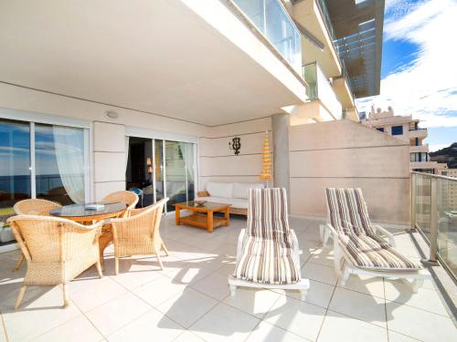 un patio con sillas, una mesa y un sofá en Apartment Sotavento by Interhome, en Calpe