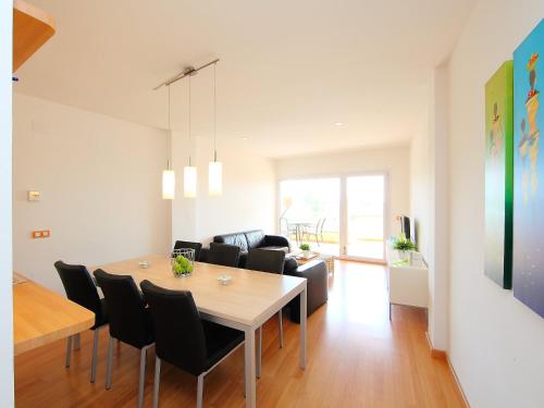 uma sala de jantar e sala de estar com mesa e cadeiras em Apartment Sun Village I by Interhome em Palau-Saverdera