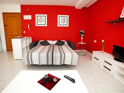 een slaapkamer met een bed en een rode muur bij Studio Apolo VI-4 by Interhome in Calpe