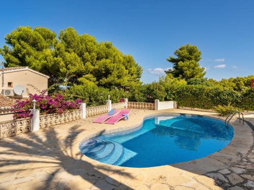 a swimming pool with two chairs and a house at Holiday Home Toscacasita by Interhome in Balcon del Mar