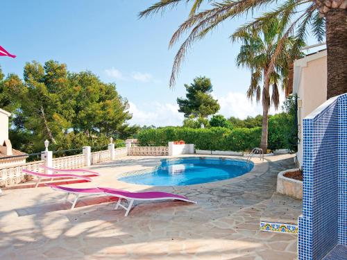 a swimming pool with chairs and a palm tree at Holiday Home Toscacasita by Interhome in Balcon del Mar