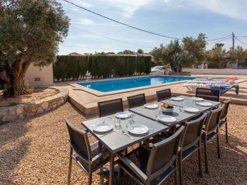 einen Tisch und Stühle vor einem Pool in der Unterkunft Villa Villa Cala Vidre B by Interhome in Les tres Cales