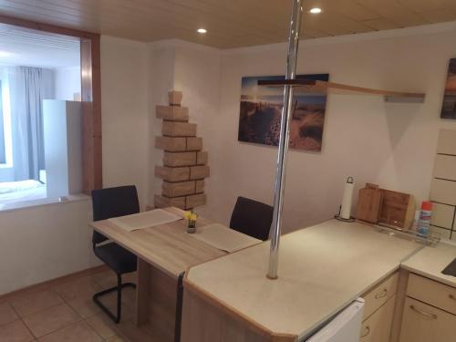 a kitchen with a counter with chairs and a table at Ferienwohnung an der Ruwer, Trier in Trier