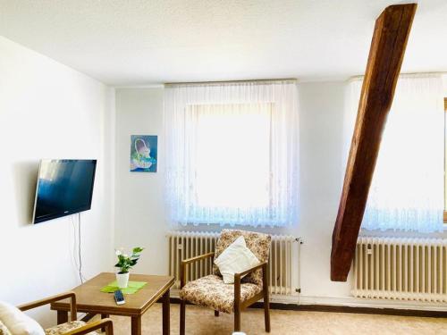 a living room with a chair and a table at Gasthaus Dernedde in Osterode