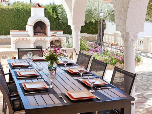 a long table with glasses and plates on a patio at Villa Rustical Mont Roig by Interhome in Miami Platja