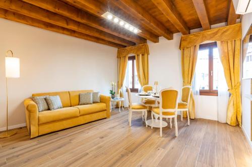 sala de estar con sofá amarillo y mesa en Laguna D'oro Luxury Apartments, en Venecia