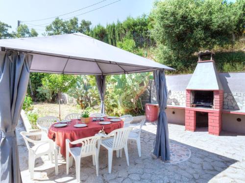 a table and chairs under an umbrella with a fireplace at Holiday Home Cris by Interhome in Mont Barbat