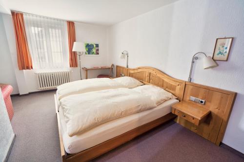 a bedroom with a bed with a wooden head board at Gästehaus Korf in Unkel