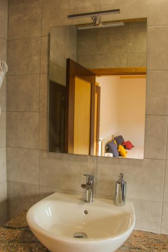 a white sink in a bathroom with a mirror at Casa de Campo Vale do Ceira in Góis