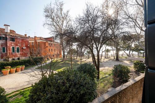 Blick auf einen Innenhof mit Bäumen und Gebäuden in der Unterkunft Laguna D'oro Luxury Apartments in Venedig