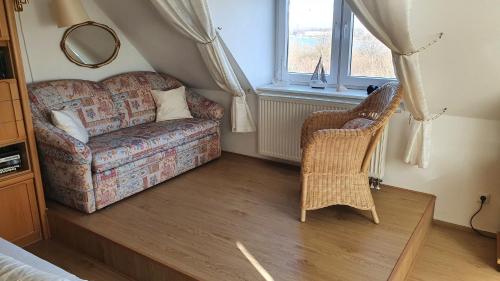 a living room with a couch and a chair at PEMATRA Ferienwohnung Marwin in Travemünde