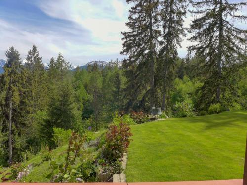 a garden with a green lawn and trees at Studio Les Faverges-6 by Interhome in Crans-Montana