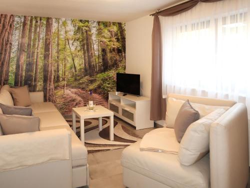 a living room with white furniture and a mural of a forest at Apartment Hartmann by Interhome in Laudenau