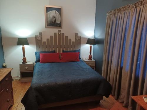 een slaapkamer met een bed en twee nachtkastjes met lampen bij Karoo Refresh Cheerful 2 Bedroom House in Oudtshoorn