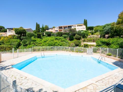 a large swimming pool with blue water at Apartment Les Coteaux de la Nartelle-17 by Interhome in Sainte-Maxime