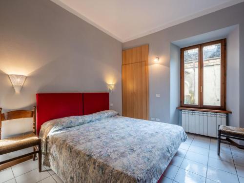 1 dormitorio con 1 cama, 1 silla y 1 ventana en Apartment Borgo Vecchio by Interhome, en Orta San Giulio