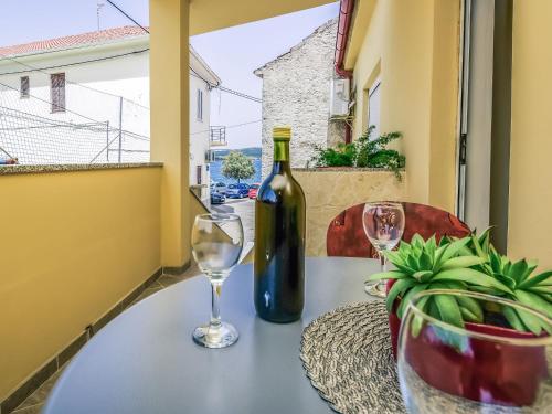 una mesa con una botella de vino y dos copas en Holiday Home Ankica by Interhome, en Pašman
