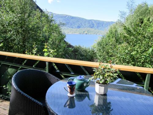 uma mesa e cadeiras numa varanda com vista para um lago em Chalet Åkrafjorden - FJH340 by Interhome em Åkra