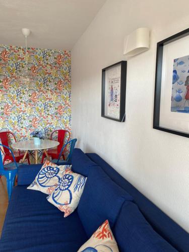 a living room with a blue couch and a table at Las Torres del Castillo, 208Marina in Costa de Antigua