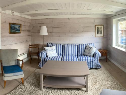 - un salon avec un canapé bleu et une table dans l'établissement Chalet Solskinn - SOW037 by Interhome, à Kvås