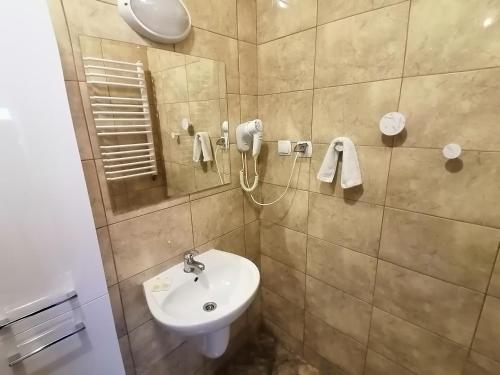 a bathroom with a sink and a mirror at Karczma Karnasów in Cisna