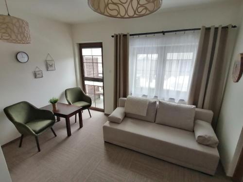 a living room with a couch and chairs and a table at Karczma Karnasów in Cisna