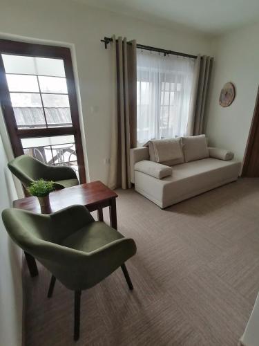 a living room with a couch and a table and chairs at Karczma Karnasów in Cisna