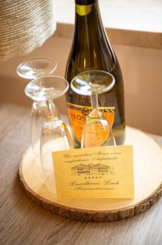 a bottle of wine and two wine glasses on a table at Landhaus Laih in Grafenau