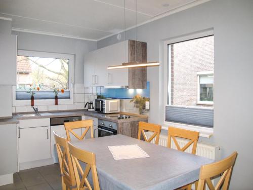 a kitchen with a table and chairs in a room at Holiday Home Nordseeblick by Interhome in Butjadingen OT Tossens