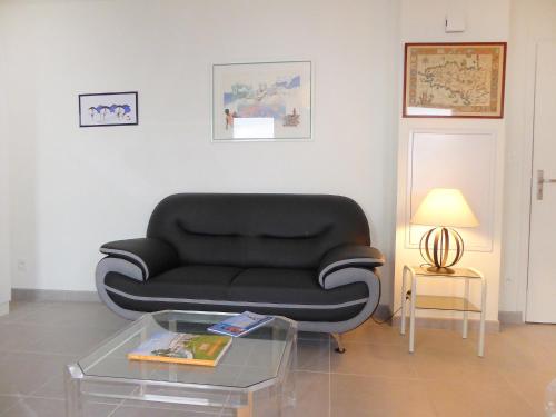 - un canapé noir dans le salon avec une table dans l'établissement Studio Les Allées du Port by Interhome, à Saint-Malo