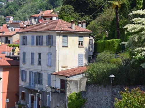 a large building with a red roof on a hill at Apartment Piazzetta by Interhome in Maccagno Inferiore