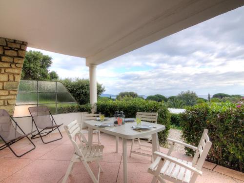 - une table et des chaises blanches sur la terrasse dans l'établissement Apartment Riva Bella-1 by Interhome, à Cavalaire-sur-Mer
