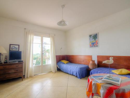- une chambre avec 2 lits, une télévision et une fenêtre dans l'établissement Apartment Riva Bella-1 by Interhome, à Cavalaire-sur-Mer