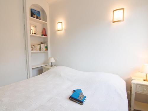 - un livre assis au-dessus d'un lit blanc dans l'établissement Apartment Riva Bella-3 by Interhome, à Cavalaire-sur-Mer
