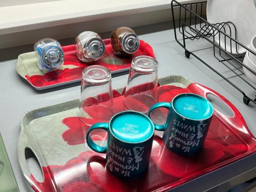 a kitchen sink with two mugs on a tray at Stonehenge Campsite & Glamping in Berwick Saint James