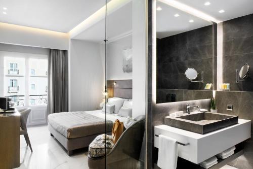 Pokój hotelowy z umywalką i łóżkiem w obiekcie Grand Hotel Palace w Salonikach