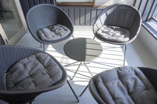 three chairs and a table on a balcony at Tiz 海岸通り in Sumoto