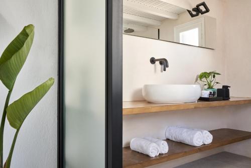 a bathroom with a sink and a mirror at Almyra Guest Houses in Paraga