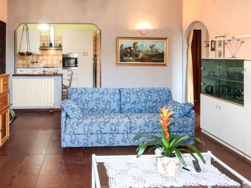 ein Wohnzimmer mit einem blauen Sofa und einem Tisch in der Unterkunft Apartment Casa dei miei by Interhome in Civezza