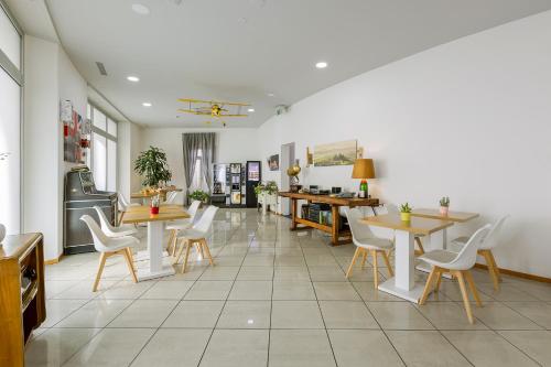 un restaurante con mesas y sillas blancas y una habitación en GuestHouse Lugano Center by LR en Lugano
