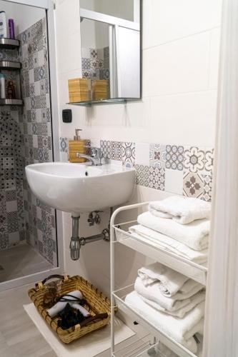 a bathroom with a sink and a mirror and towels at A Casa di Nonna Ada in Manduria