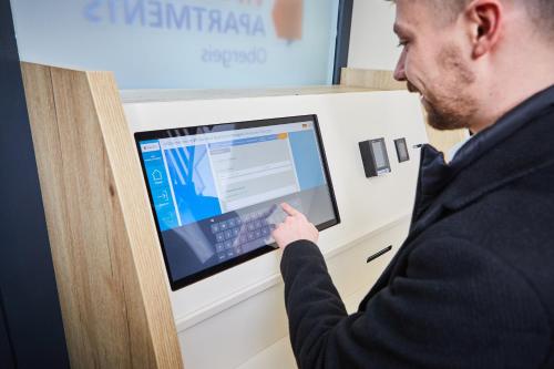 a man in a suit pointing at a computer screen at VR-Serviced Apartments Obergeis in Neuenstein