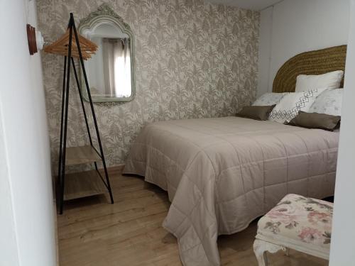 - une chambre avec un lit et un miroir dans l'établissement EL HECHIZO DEL BAILÓN, à Zuheros
