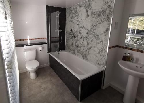 La salle de bains est pourvue d'une baignoire, de toilettes et d'un lavabo. dans l'établissement The Langstrath Country Inn, à Keswick