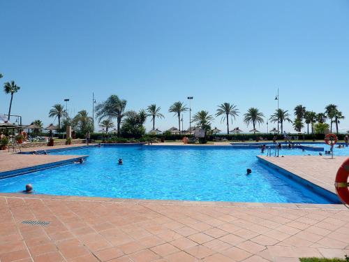 a large swimming pool with people in the water at Apartment Playamar by Interhome in Torremolinos