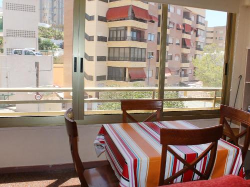stół i krzesła w pokoju z oknem w obiekcie Apartment Cardenal II by Interhome w mieście Cala de Finestrat