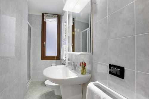 a bathroom with a sink and a toilet and a mirror at Bricola Biennale Apartments in Venice
