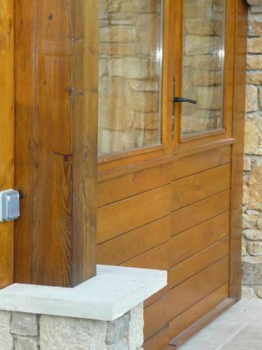 une porte en bois avec une fenêtre sur un mur en pierre dans l'établissement Gîte dans propriété périgourdine, à Pechpialat