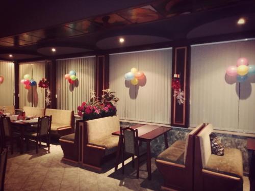 a restaurant with chairs and tables and balloons on the wall at Discret Hotel & Restaurant in Vladaya