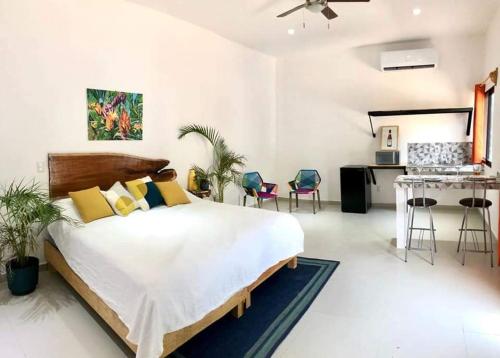 a bedroom with a bed and a desk and chairs at Villas Chital Bacalar in Bacalar